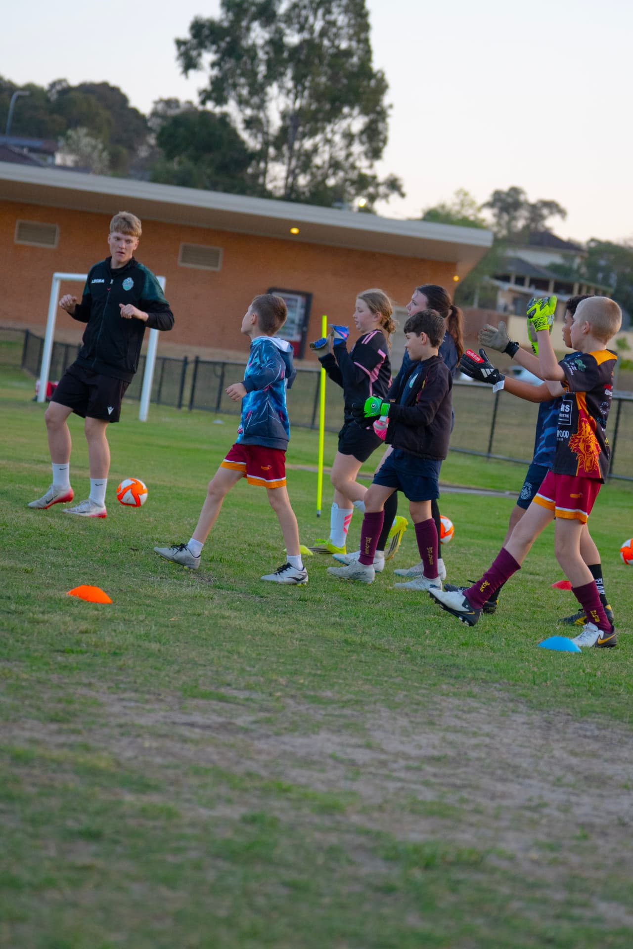 NextGen coach leading a line of goalkeepers through a footwork and catching drill