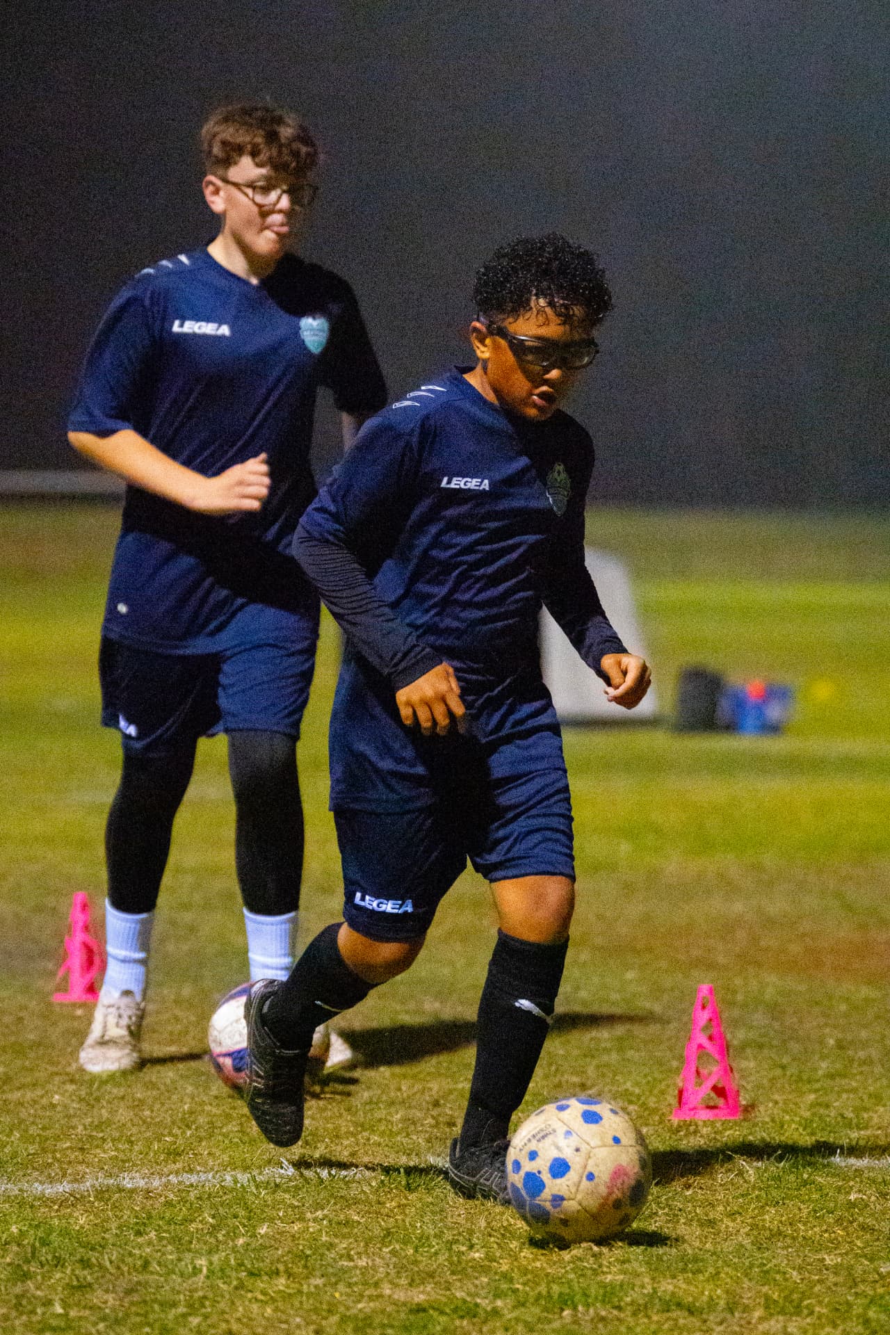 NextGen boys dribbling between cones at academy training