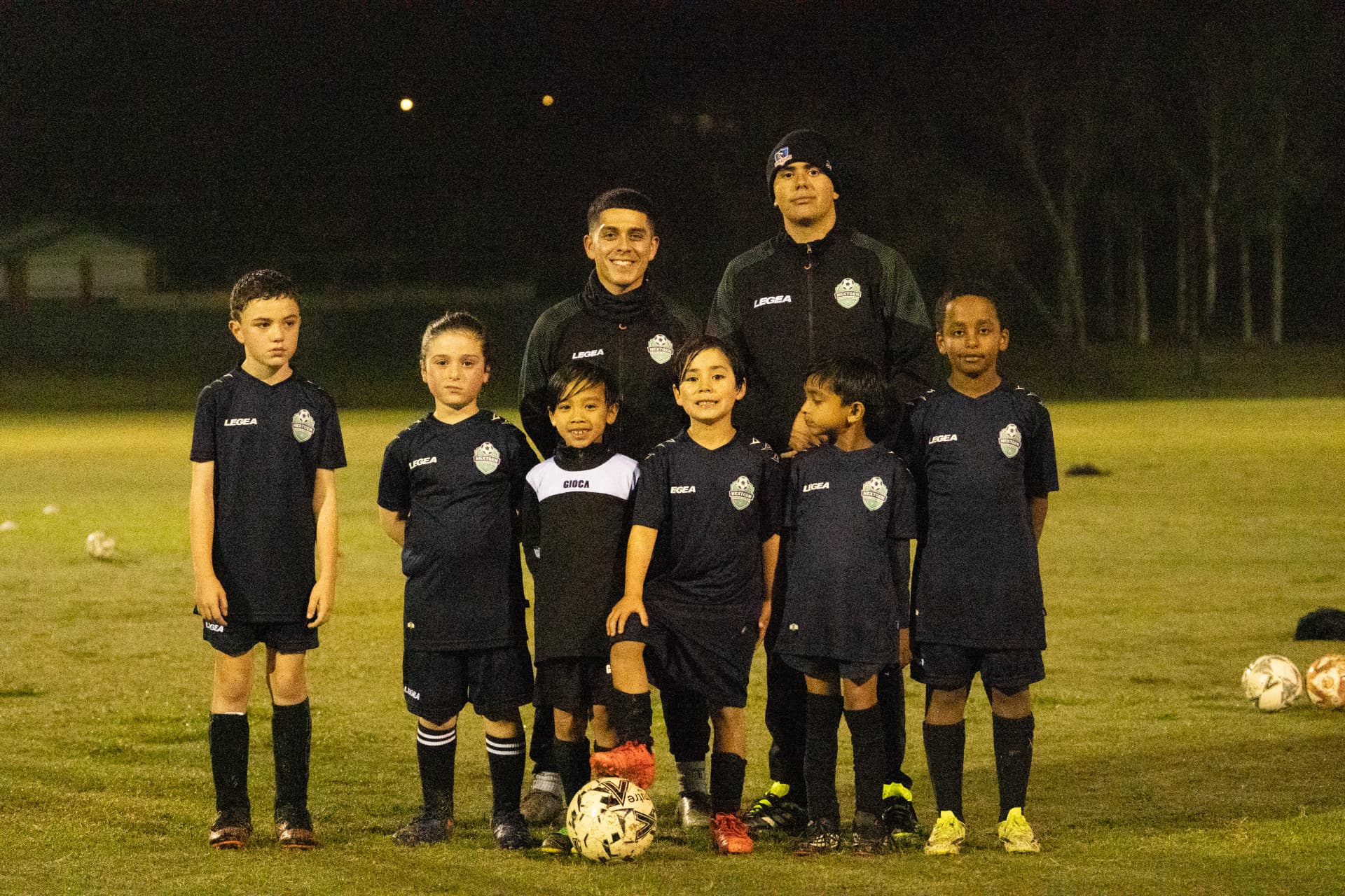 NextGen boys and coaches posing together after an evening session