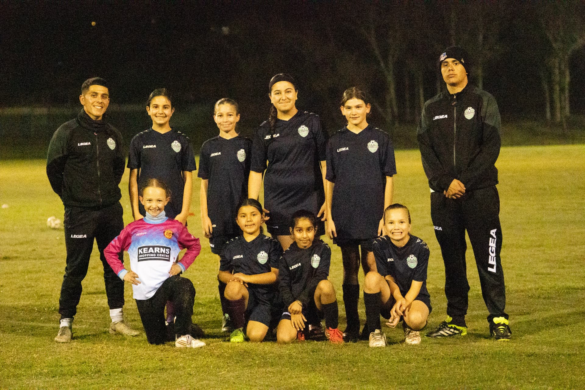 NextGen girls team with their coaches on the training pitch