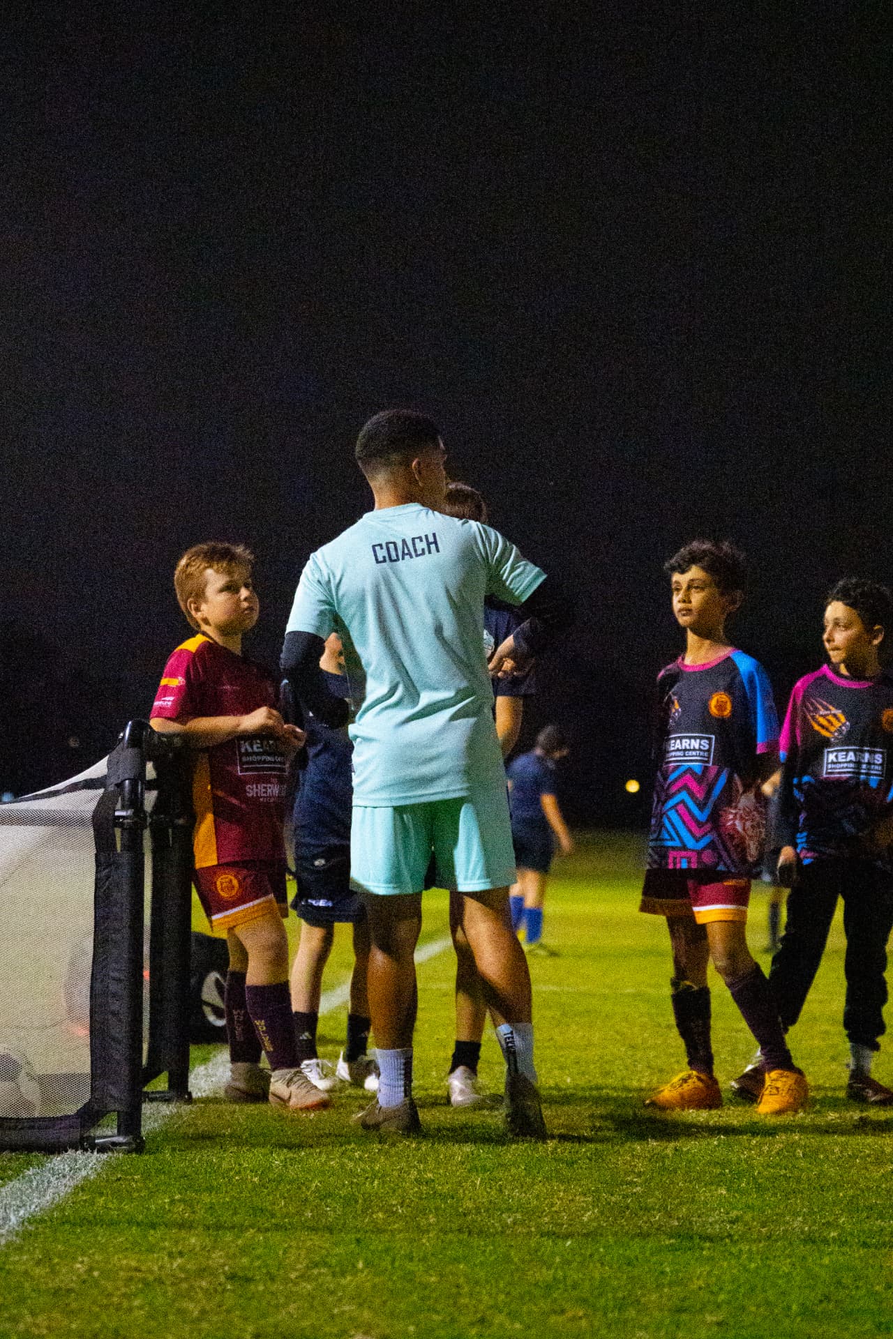 NextGen coach giving instructions to young players beside the goal